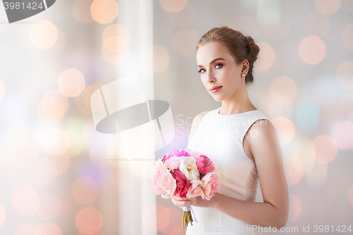 Image of bride or woman in white dress with flower bunch