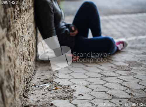 Image of close up of addict woman and drug syringes