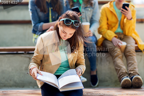Image of high school student girl reading book outdoors
