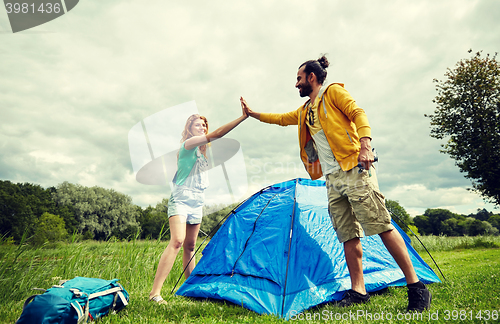 Image of happy couple setting up tent outdoors