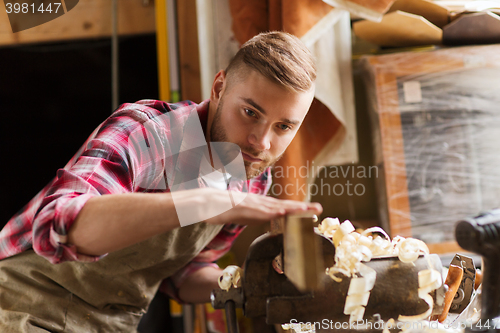 Image of carpenter working with wood plank at workshop