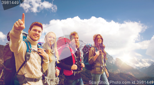 Image of group of smiling friends with backpacks hiking