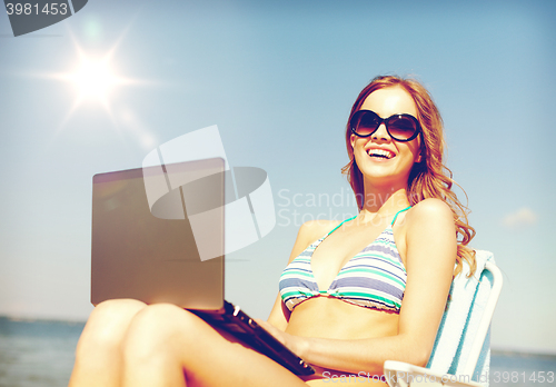 Image of girl looking at tablet pc on the beach