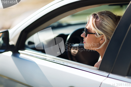 Image of happy teenage girl or young woman in car