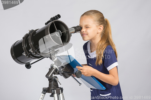 Image of The young astronomer happy to look through the telescope recording observations