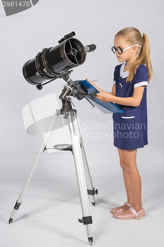 Image of The young astronomer with glasses writes observations