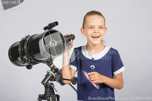 Image of The young astronomer happily standing on the starry sky