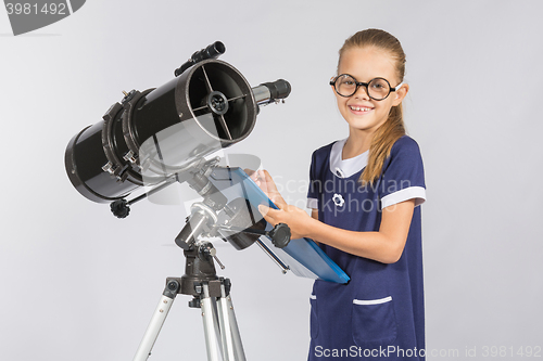 Image of The young astronomer happy to look through the telescope recording observations