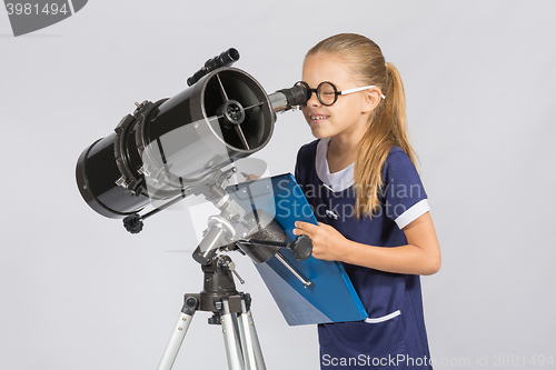 Image of The young astronomer happy to look through the telescope recording observations