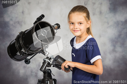 Image of Seven-year girl adjusts the telescope and looked into the frame