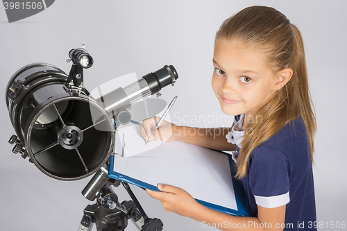 Image of Young Astronomer writes the results of observations in the document