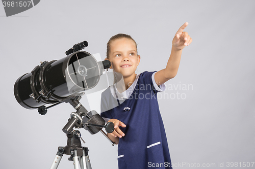 Image of The young astronomer pointing at the starry sky