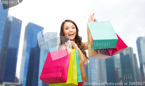 Image of happy woman with shopping bags over singapore city