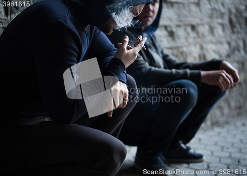 Image of close up of young men smoking cigarettes