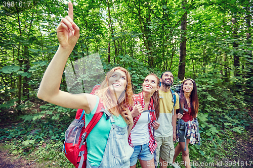 Image of group of smiling friends with backpacks hiking