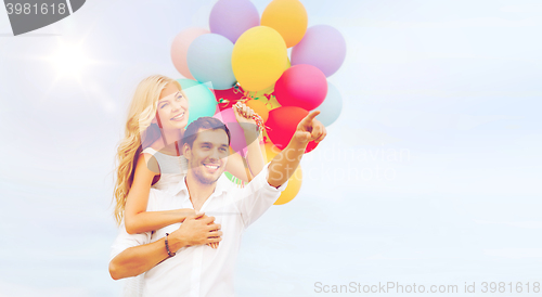 Image of couple with colorful balloons at sea side