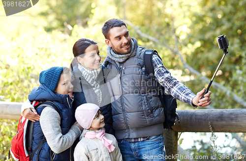 Image of happy family with smartphone selfie stick in woods