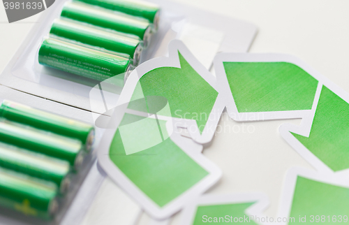 Image of close up of batteries and green recycling symbol