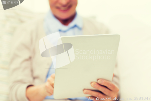 Image of close up of senior woman with tablet pc at home