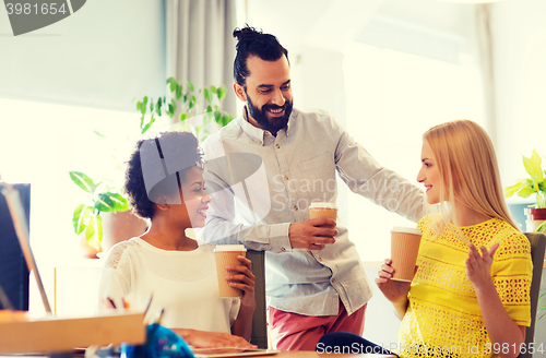 Image of business team with coffee cups talking at office