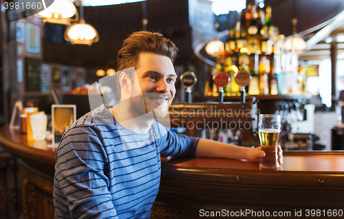 Image of happy man drinking beer at bar or pub