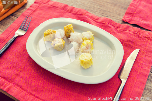 Image of plate of spring rolls with rice on table