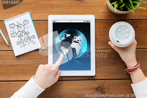 Image of close up of woman with tablet pc on wooden table