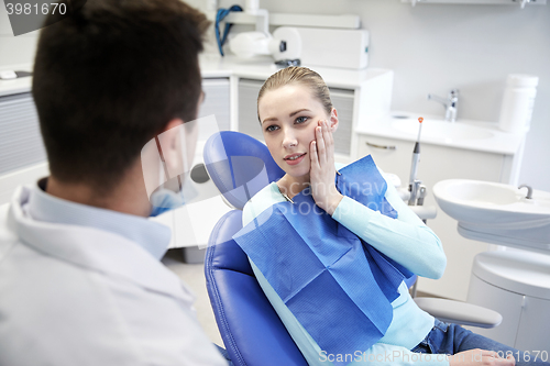 Image of male dentist with woman patient at clinic