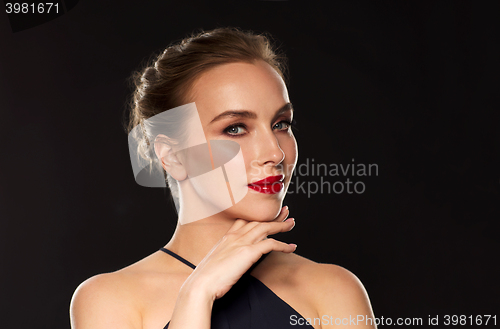Image of beautiful woman in black over dark background