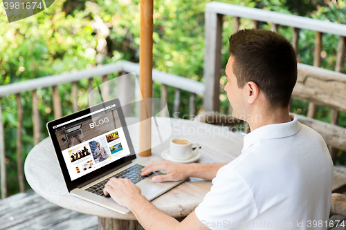 Image of close up of man with laptop blogging on terrace