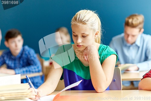 Image of group of students with books writing school test