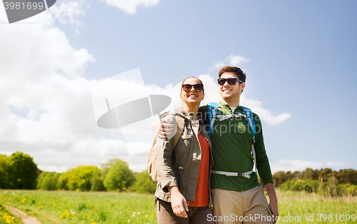 Image of happy couple with backpacks hiking outdoors