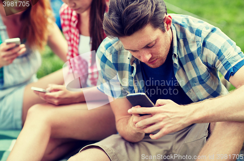 Image of friends with smartphone at camping