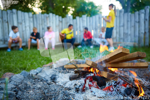 Image of happy kids having fun around camp fire