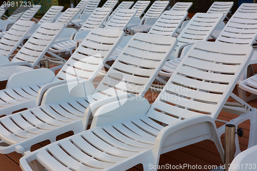 Image of number of empty sunbeds at the pool early in the morning