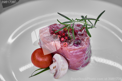 Image of raw beef meat fillet with peppercorn and thyme ready to grill