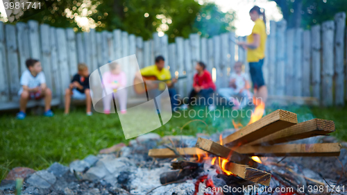 Image of happy kids having fun around camp fire