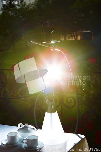 Image of white teapot, two cups and sun. Garden party