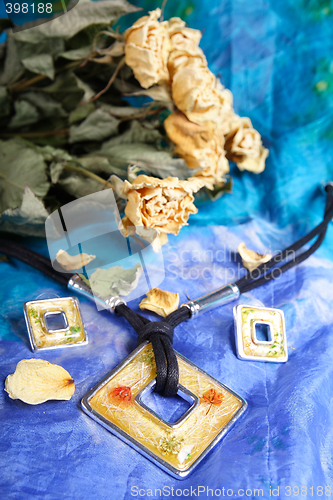 Image of Dried bunch of yellow roses and modern necklace