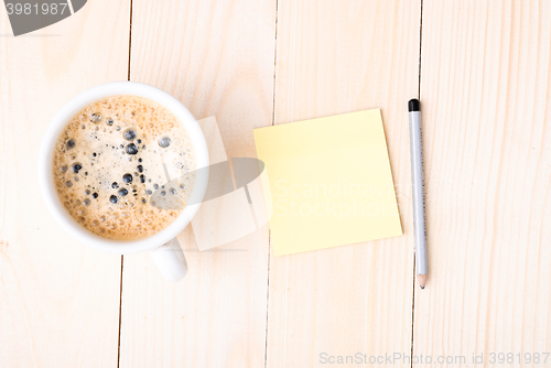 Image of Wood desk with office supplies and cup of coffee