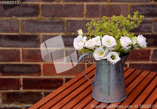 Image of White prairie gentians in a jug on a wooden table