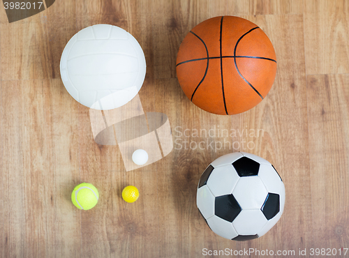 Image of close up of different sports balls set on wood