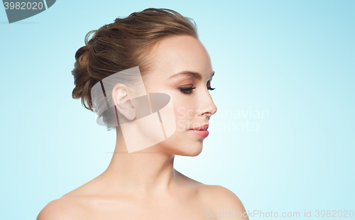 Image of beautiful young woman face over blue background