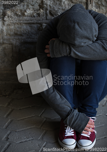 Image of close up of addict woman hiding her face on street