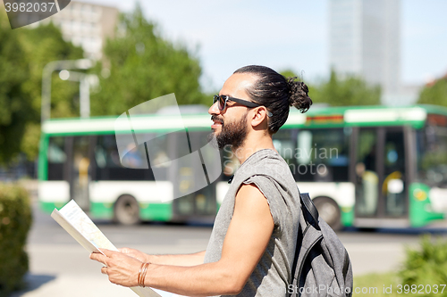 Image of man traveling with backpack and map in city