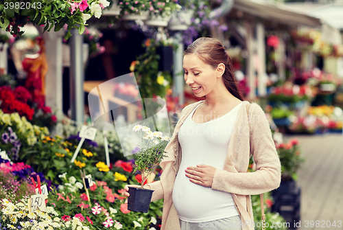 Image of pregnant woman choosing flowers at street market