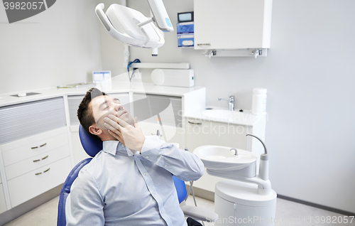 Image of man having toothache and sitting on dental chair