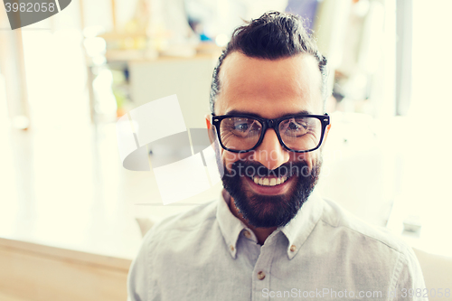 Image of smiling man with eyeglasses and beard at office