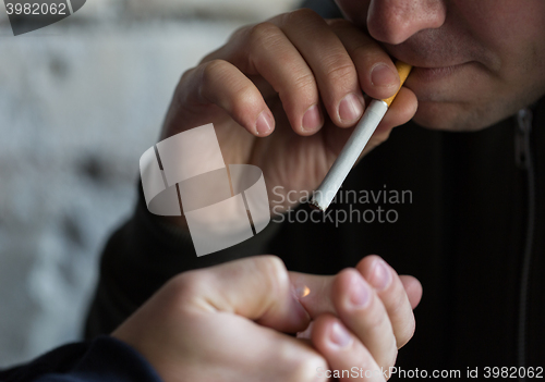 Image of close up of young people smoking cigarette