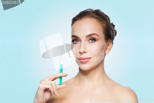 Image of beautiful woman holding syringe with injection